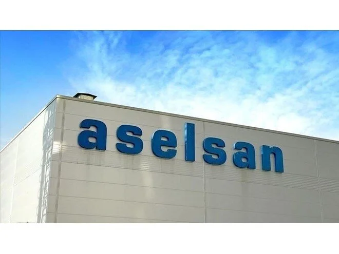 Mavi gökyüzü altında beyaz bina cephesinde mavi ASELSAN yazısı