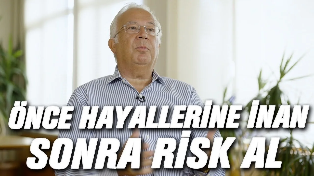 Çizgili gömlekli, gözlüklü yaşlı bir adam; “Önce hayallerine inan, sonra risk al” yazılı video karesi
